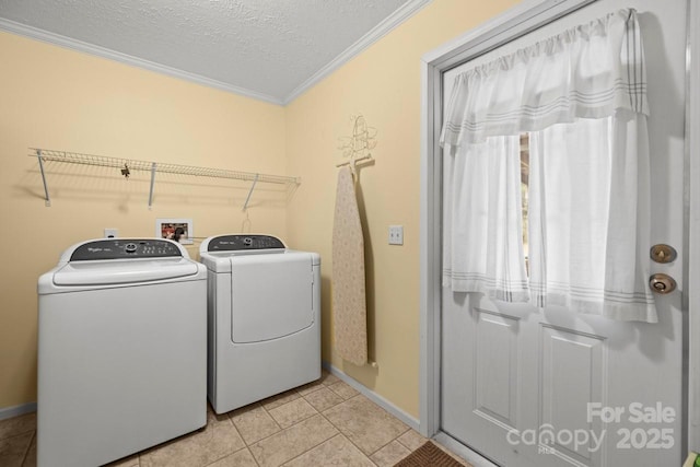 laundry area with washing machine and dryer, light tile patterned flooring, a textured ceiling, and crown molding