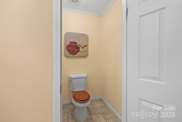 bathroom featuring crown molding, toilet, tile patterned flooring, and a textured ceiling