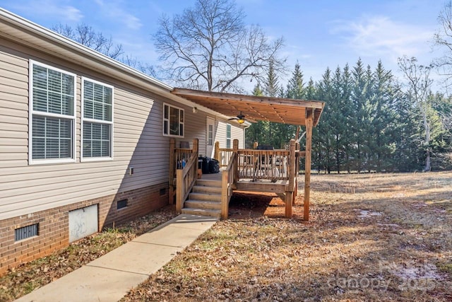 doorway to property featuring a wooden deck and ceiling fan