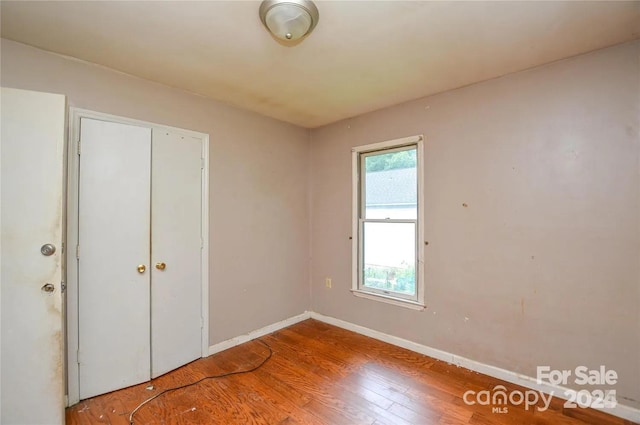 unfurnished bedroom with wood-type flooring and a closet