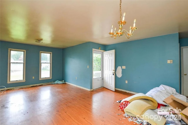 interior space featuring an inviting chandelier, wood-type flooring, and multiple windows