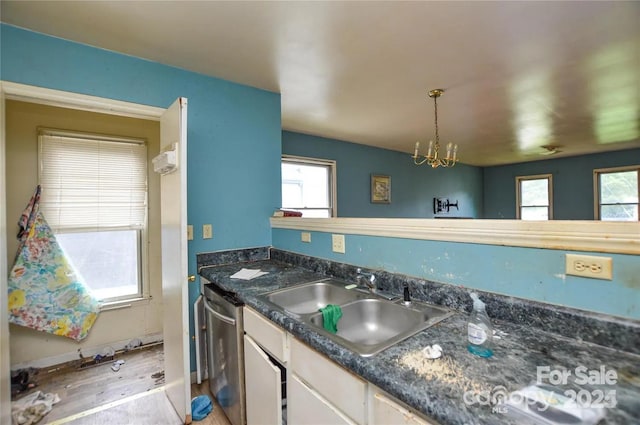 kitchen featuring dishwasher, white cabinets, sink, decorative light fixtures, and a chandelier