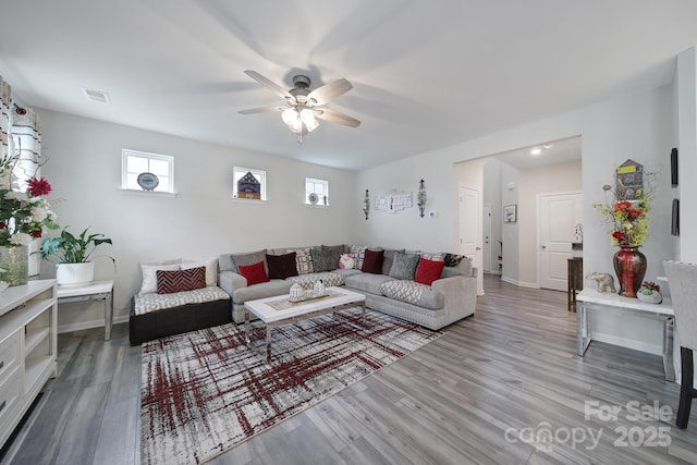 living room with visible vents, baseboards, ceiling fan, and wood finished floors