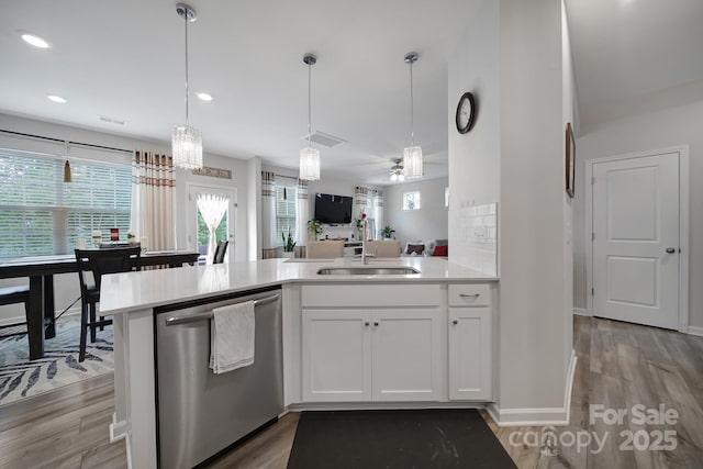 kitchen featuring light wood-type flooring, light countertops, plenty of natural light, and dishwasher