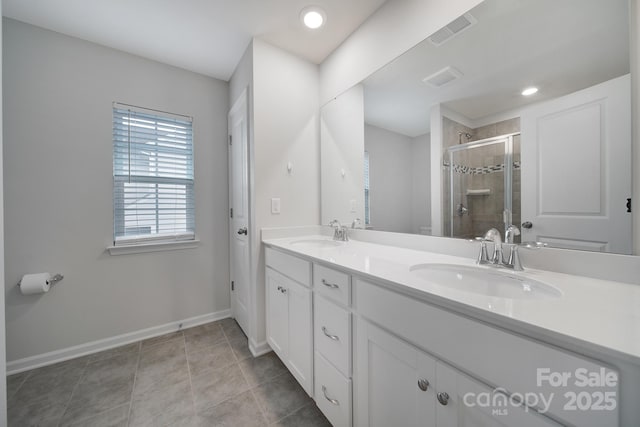 full bath with a sink, baseboards, a shower stall, and visible vents