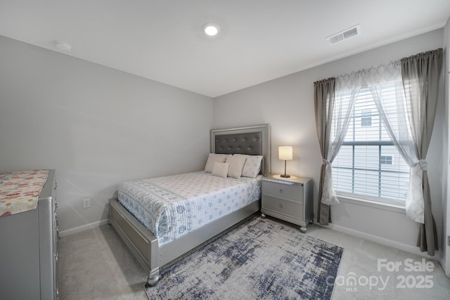 bedroom featuring baseboards, multiple windows, and light carpet