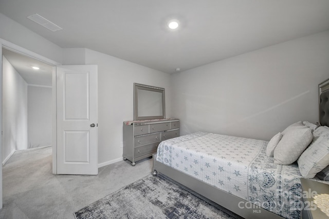 bedroom with baseboards and light carpet