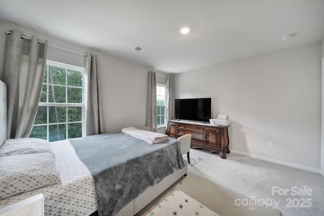 bedroom with light colored carpet, baseboards, visible vents, and multiple windows