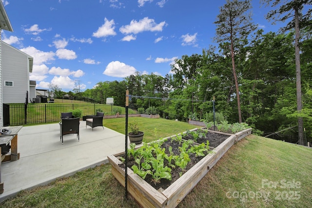 view of yard featuring fence, a patio, and a vegetable garden