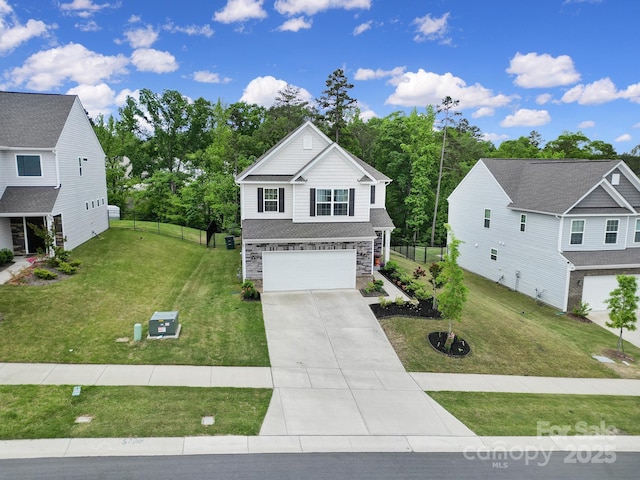 view of front of house featuring a garage, fence, a front yard, stone siding, and concrete driveway