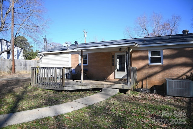 back of house featuring central air condition unit and a wooden deck