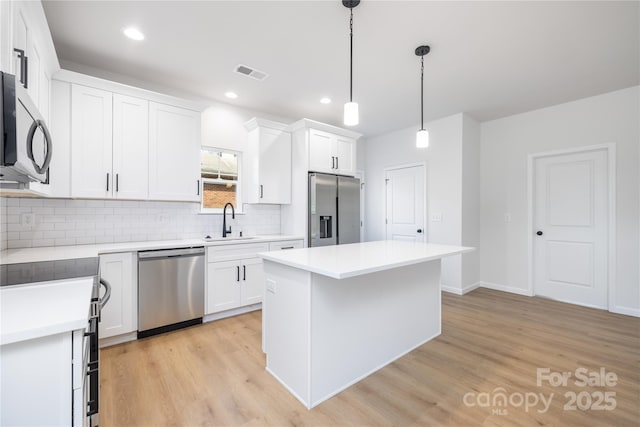 kitchen with sink, white cabinets, and appliances with stainless steel finishes