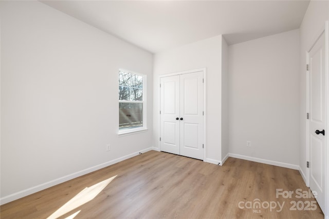 unfurnished bedroom with light hardwood / wood-style floors and a closet