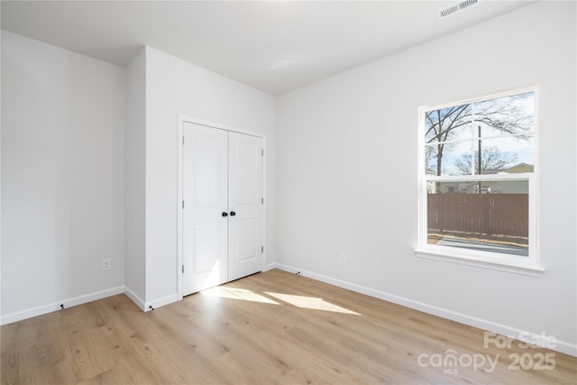 unfurnished bedroom with a closet and light hardwood / wood-style floors