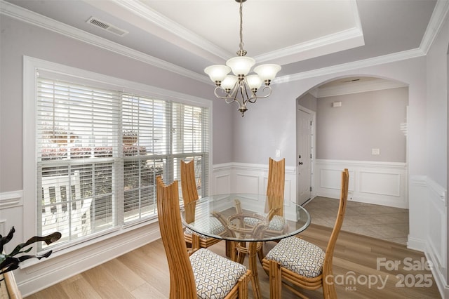 dining area with an inviting chandelier, crown molding, and hardwood / wood-style floors