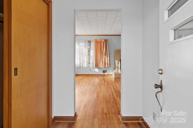 corridor with crown molding and light hardwood / wood-style flooring