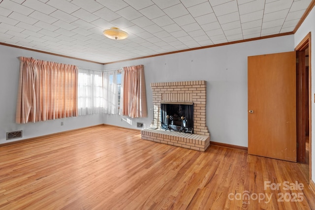 unfurnished living room with light hardwood / wood-style floors, crown molding, and a fireplace