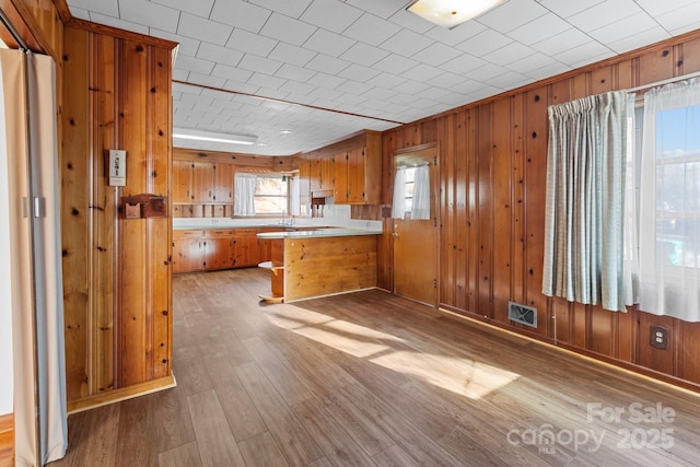 kitchen featuring light hardwood / wood-style flooring, a kitchen bar, and kitchen peninsula