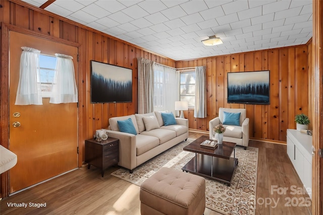 living room featuring light hardwood / wood-style flooring and wooden walls