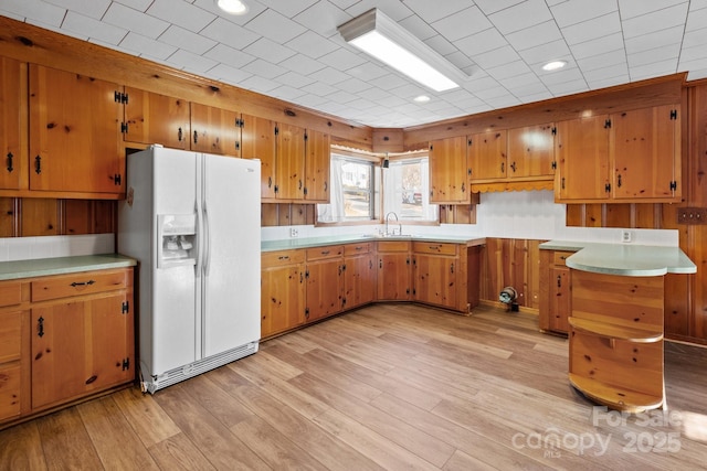 kitchen featuring sink, light hardwood / wood-style floors, and white refrigerator with ice dispenser