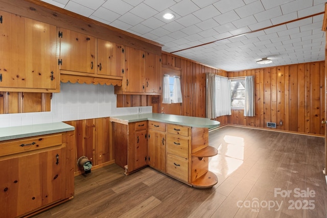 kitchen with kitchen peninsula and hardwood / wood-style flooring