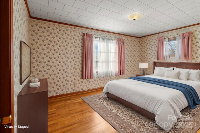 bedroom with multiple windows, hardwood / wood-style floors, and crown molding