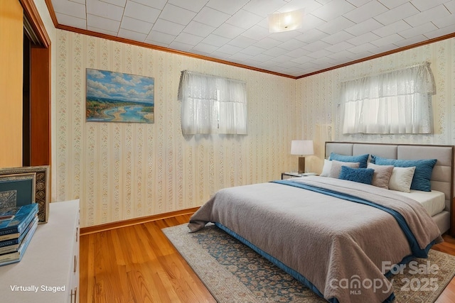 bedroom featuring crown molding and wood-type flooring