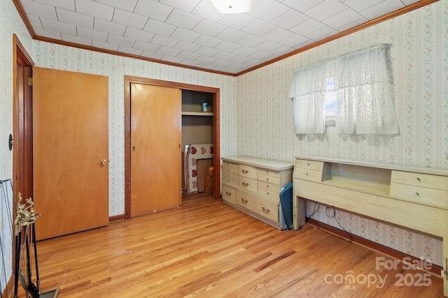 unfurnished bedroom featuring wood-type flooring and ornamental molding