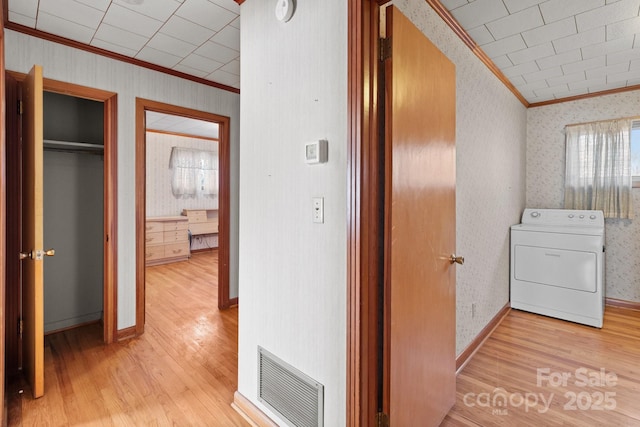 hallway with light hardwood / wood-style floors, washer / clothes dryer, and crown molding