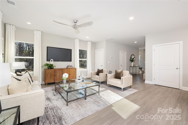 living room with plenty of natural light, light hardwood / wood-style floors, and ceiling fan