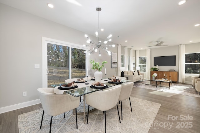 dining area with ceiling fan with notable chandelier and light hardwood / wood-style floors