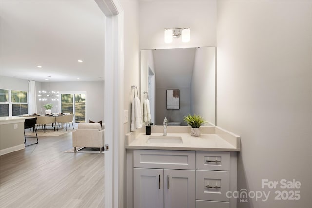 bathroom featuring vanity, a notable chandelier, and hardwood / wood-style flooring