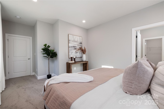 carpeted bedroom featuring a walk in closet and a closet