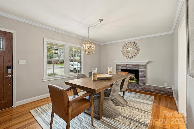 dining space with light wood-type flooring, crown molding, and an inviting chandelier