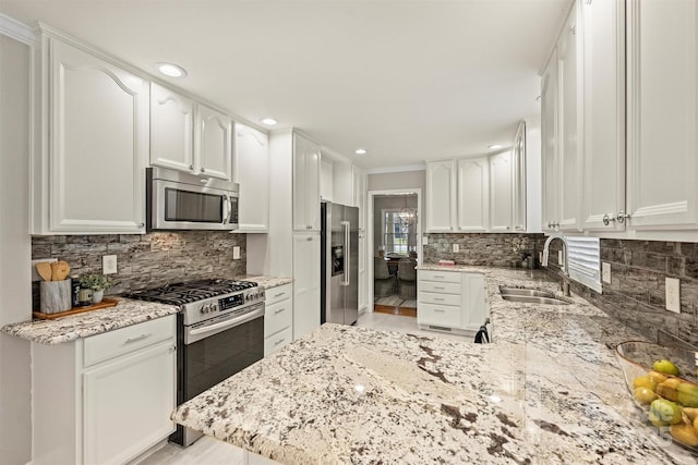 kitchen with sink, stainless steel appliances, light stone countertops, and white cabinets