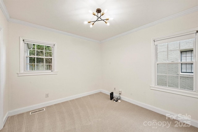 carpeted empty room featuring ornamental molding and a notable chandelier