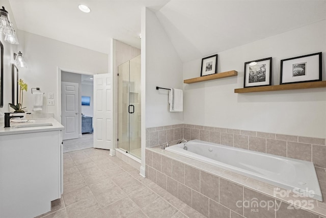 bathroom with tile patterned floors, separate shower and tub, vanity, and lofted ceiling