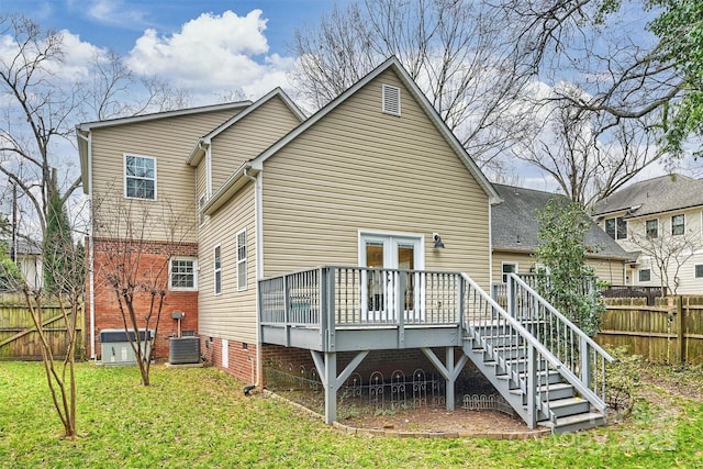 rear view of property featuring a deck, a yard, and central air condition unit