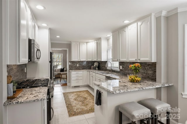 741 Mcalway Rd, Charlotte, NC 28211 - kitchen with stainless steel appliances, a sink, a peninsula, backsplash, and light stone counters