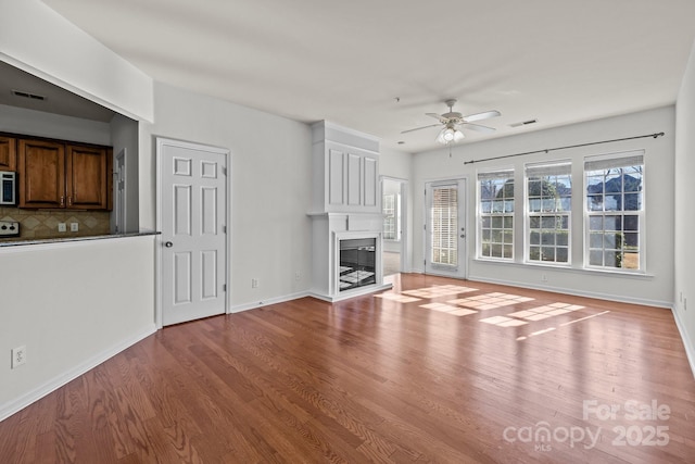 unfurnished living room featuring wood-type flooring and ceiling fan