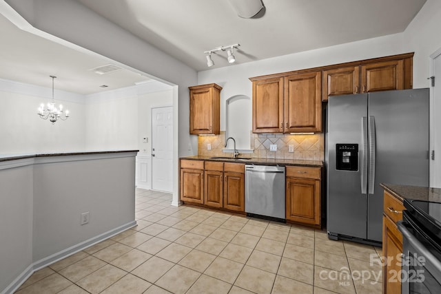 kitchen with an inviting chandelier, sink, light tile patterned floors, appliances with stainless steel finishes, and tasteful backsplash