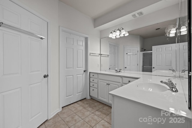 bathroom featuring tile patterned flooring, vanity, and walk in shower