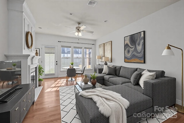 living room featuring ceiling fan and light hardwood / wood-style floors