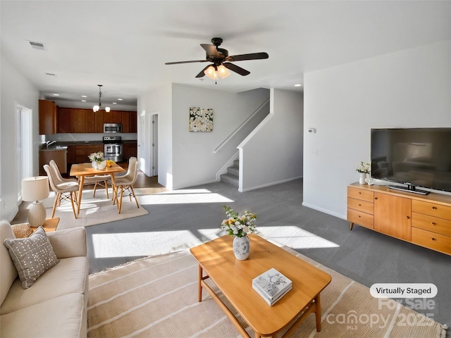 carpeted living room featuring ceiling fan