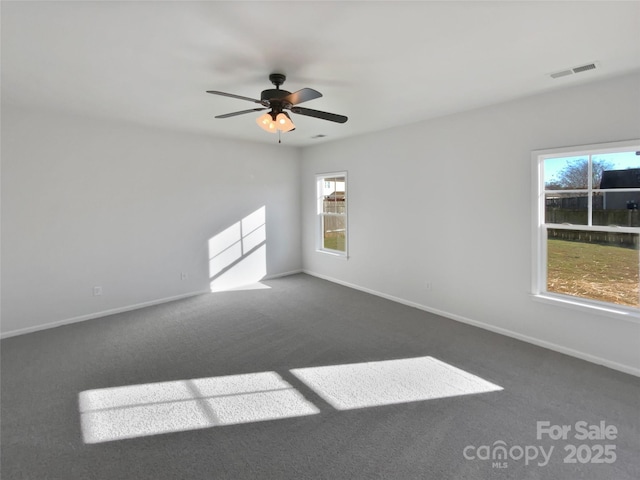 spare room with ceiling fan and dark carpet