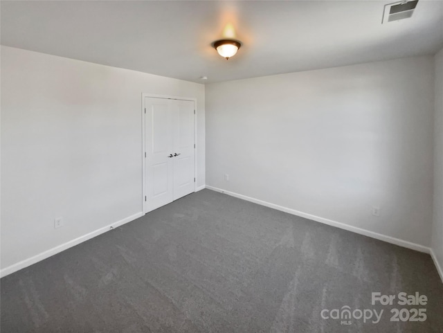 empty room with dark colored carpet