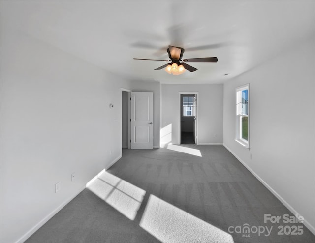 unfurnished room with dark carpet and ceiling fan