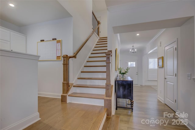 stairs with a chandelier, recessed lighting, baseboards, and wood finished floors