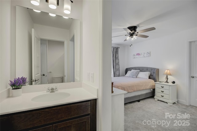 bathroom featuring toilet, ceiling fan, and vanity