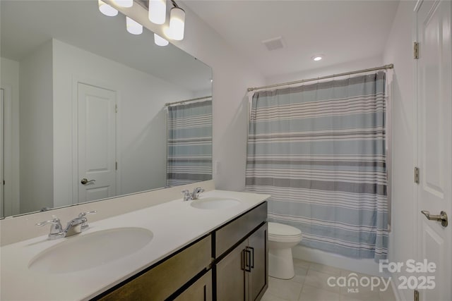 full bath with double vanity, a sink, toilet, and tile patterned floors